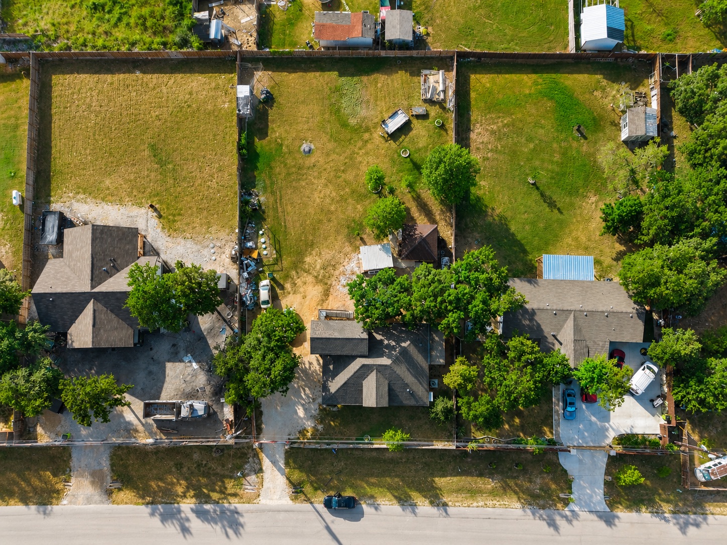 158 Buena Fortuna Road Elgin, TX 78621 - Photo 2 of 40 An aerial perspective reveals sprawling lots with ample green space, mature trees, and well-maintained properties, offering a serene neighborhood setting.