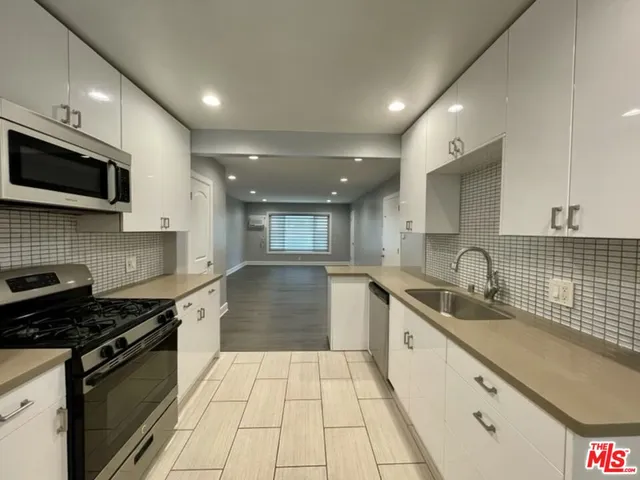 a large kitchen with stainless steel appliances granite countertop a sink and a stove