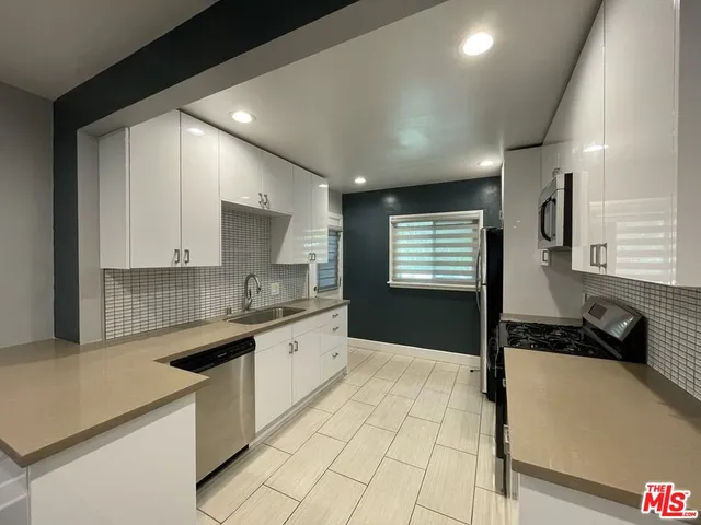 a large kitchen with granite countertop a sink and cabinets