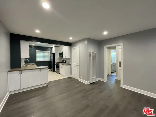 a view of living room with stainless steel appliances wooden floor and living room view
