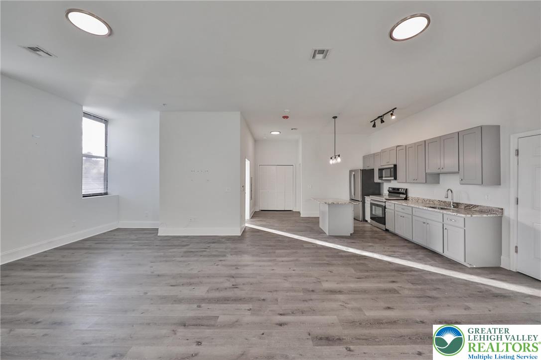 10 West Goepp Street, Unit 207 Bethlehem, PA 18018 - Photo 11 of 24 a view of a kitchen with a sink wooden cabinets and appliances