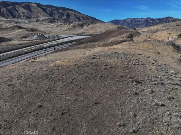 a view of a dry yard with mountains in the background
