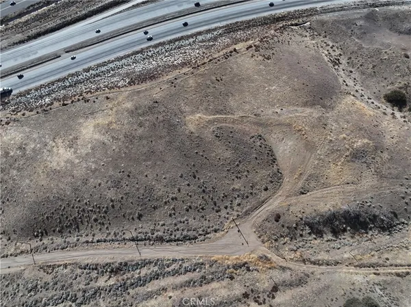 a view of a dry yard with wooden fence