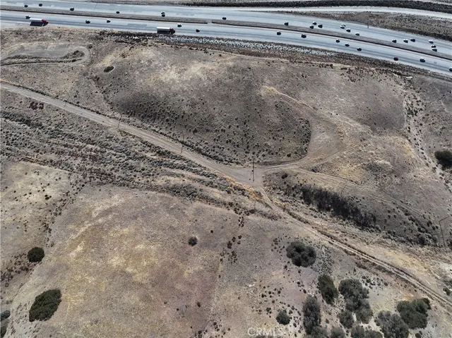 a view of a dry yard with wooden fence