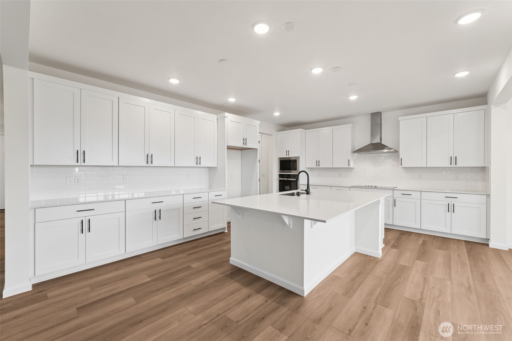 723 South Davis Street, Unit 103 Buckley, WA 98321 - Photo 4 of 13 a kitchen with white cabinets appliances and wooden floor