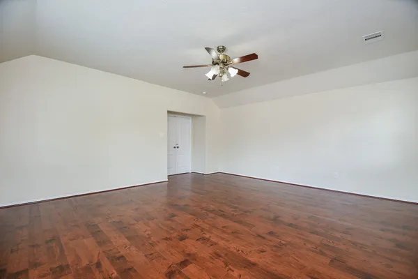 a view of empty room with wooden floor