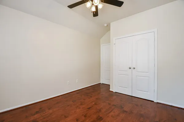an empty room with a chandelier fan