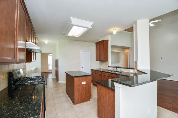 a kitchen with granite countertop a stove and a sink