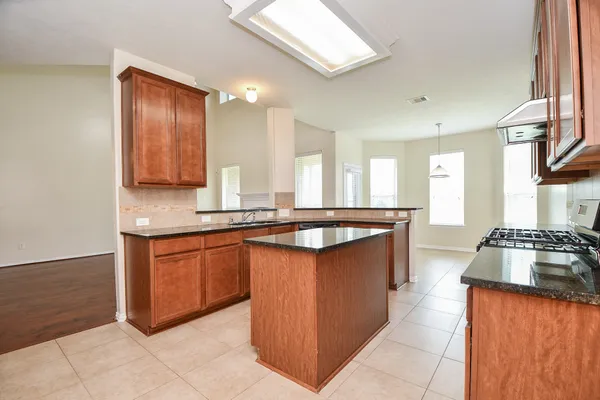 a large kitchen with stainless steel appliances granite countertop a stove a sink and a refrigerator