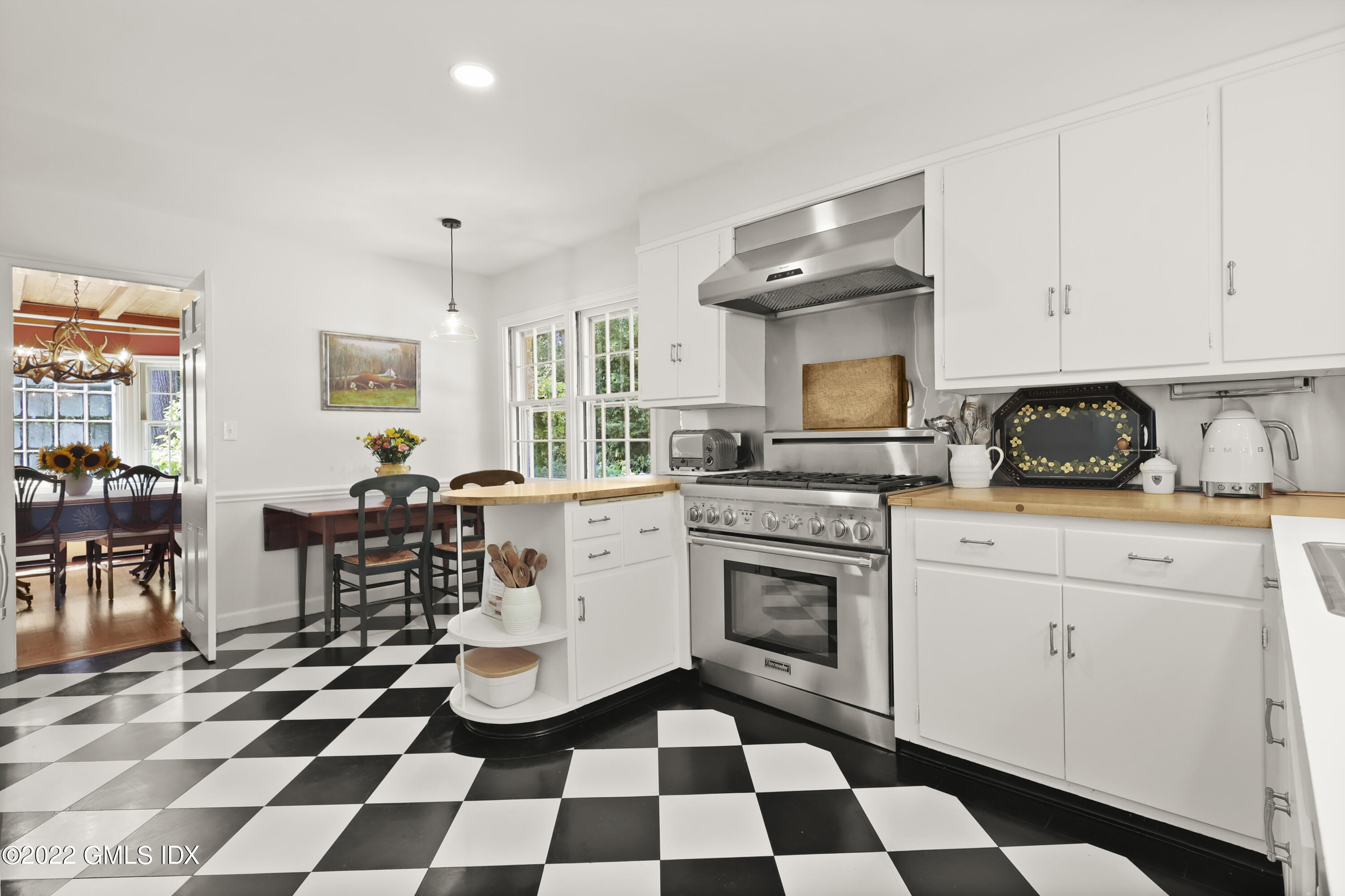 141 Hendrie Avenue Riverside, CT 06878 - Photo 11 of 34 a kitchen with a checkered floor and white cabinets