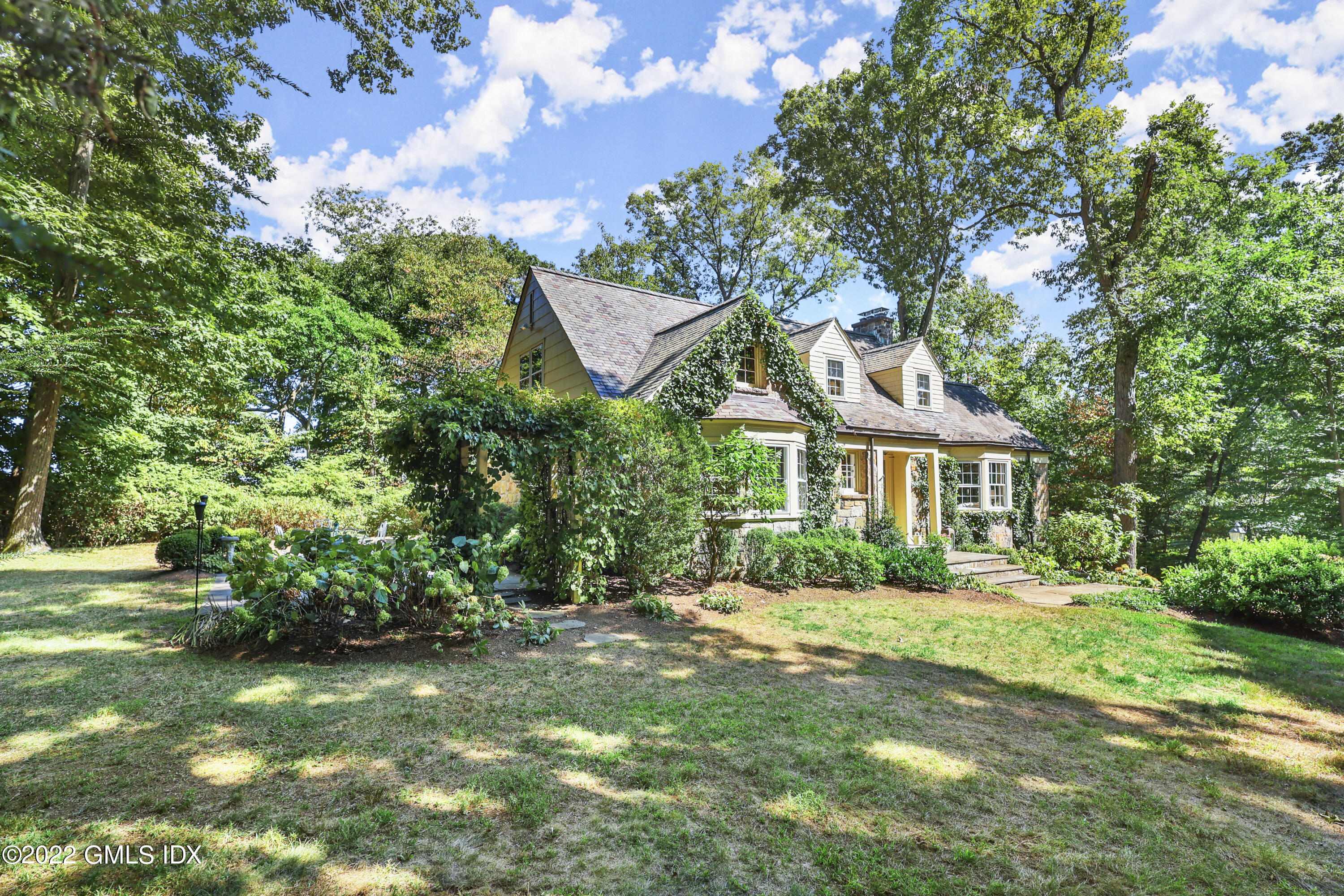 141 Hendrie Avenue Riverside, CT 06878 - Photo 2 of 34 a front view of a house with a garden