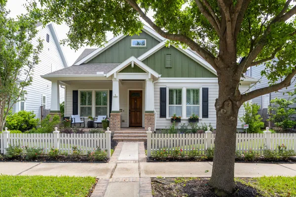 a front view of a house with a garden and plants