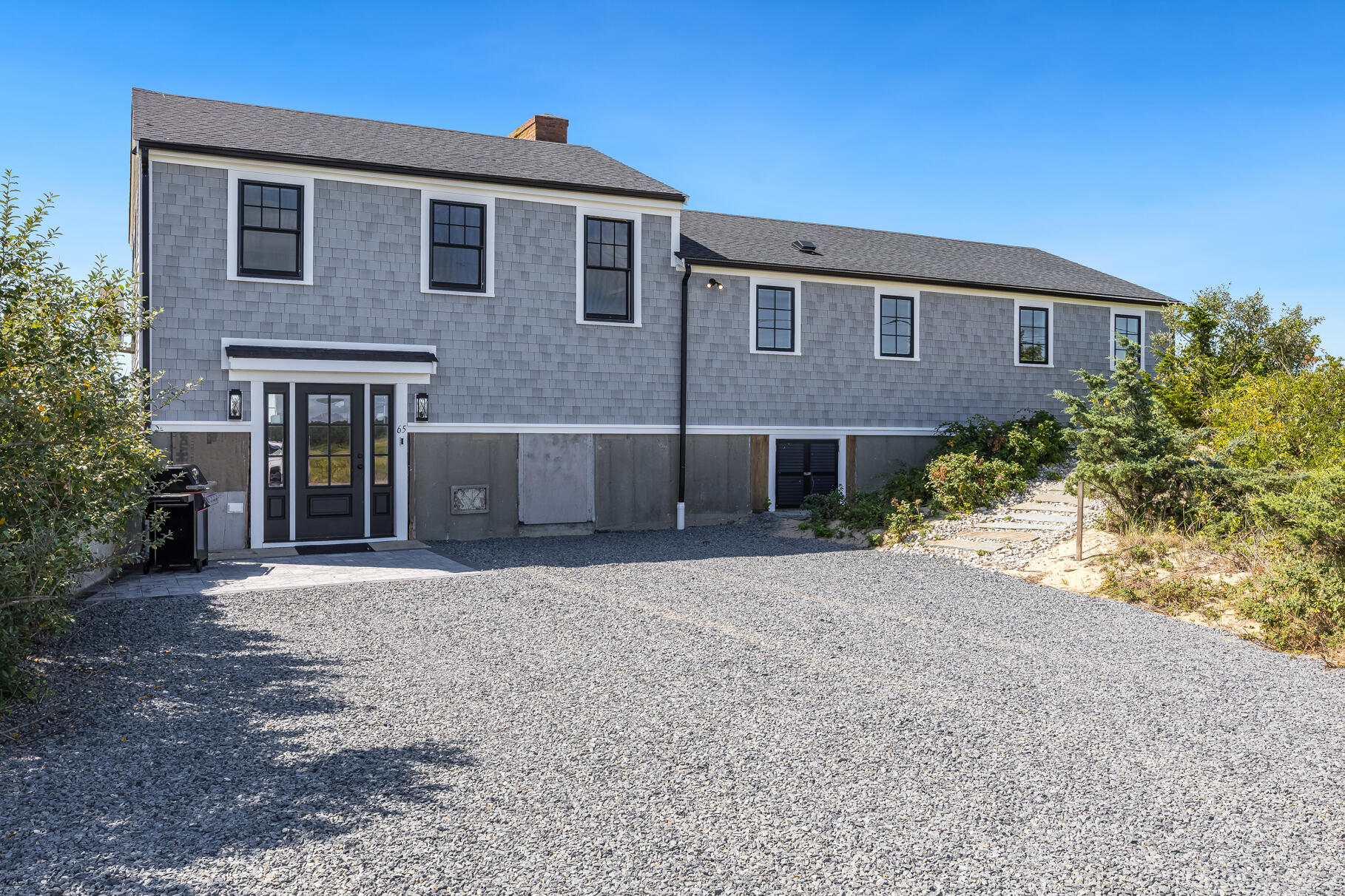 65 Harmes Way Eastham, MA 02642 - Photo 3 of 35 a front view of a house with a yard and garage