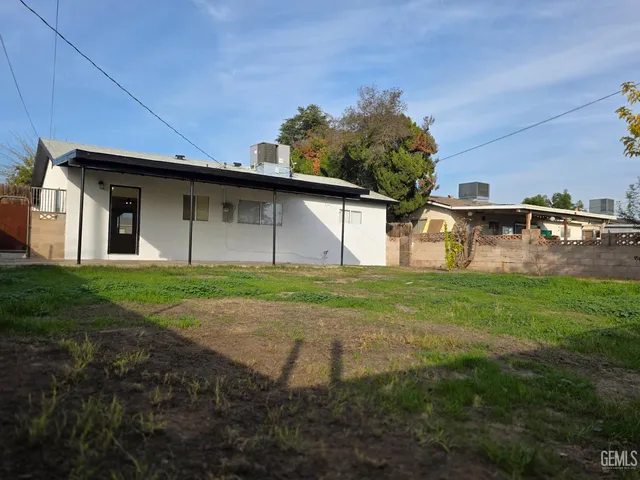 a view of a backyard with table and chairs and potted plants