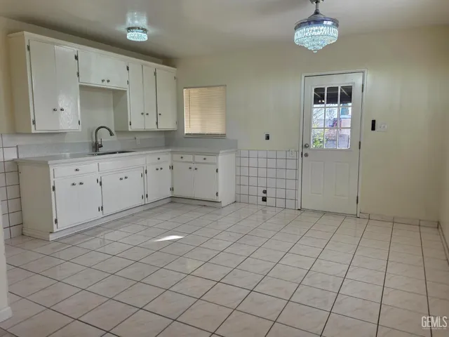 a view of a kitchen with white cabinets