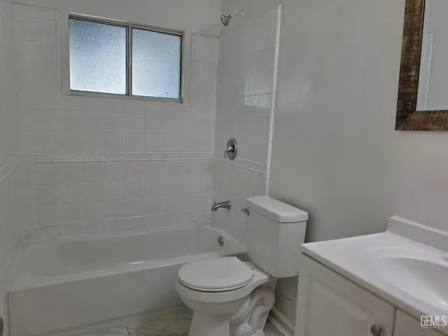 a white toilet sitting next to a bath tub