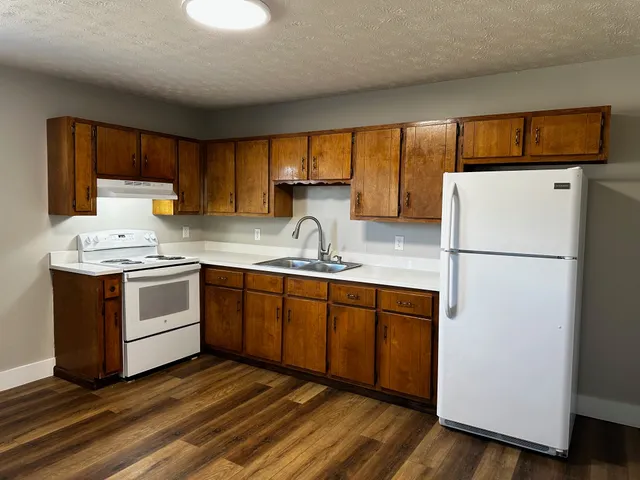 a kitchen with a refrigerator sink and cabinets