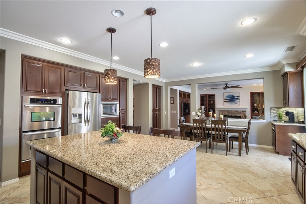 28483 Nautical Point Circle Menifee, CA 92585 - Photo 5 of 44 a kitchen with stainless steel appliances granite countertop sink stove and refrigerator