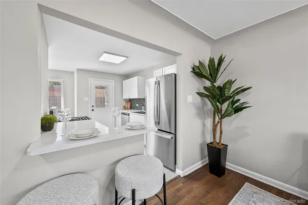 a dining room with furniture and a potted plant