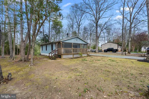 a front view of a house with a yard covered with trees