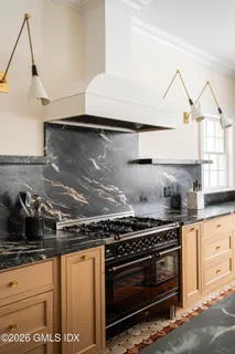 a kitchen with stainless steel appliances granite countertop a sink a stove and a microwave