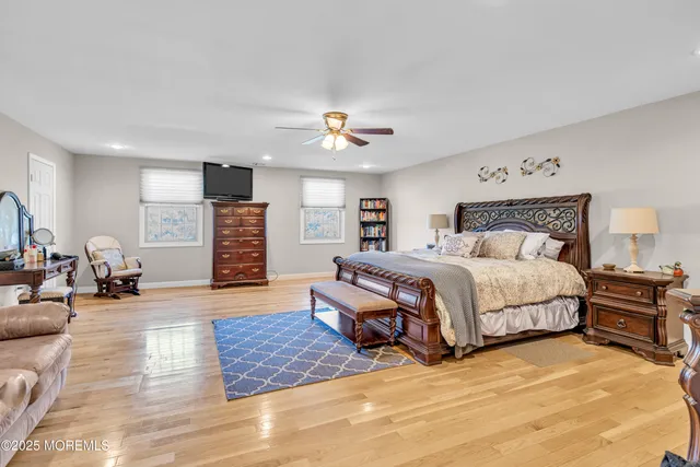 a spacious bedroom with a bed a couch and a chandelier