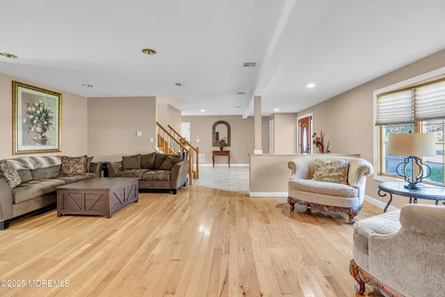 a living room with furniture and a wooden floor