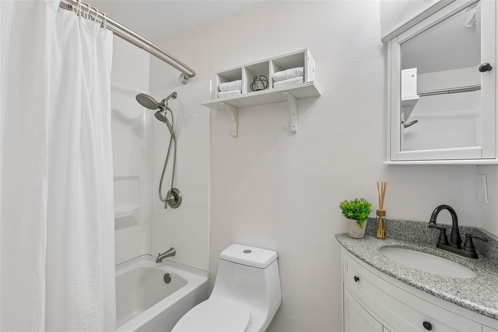 1548 Timbercreek Drive Howe, TX 75459 - Photo 12 of 24 a bathroom with a granite countertop sink a toilet and a tub