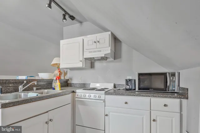 a kitchen with cabinets appliances a sink and a counter top space