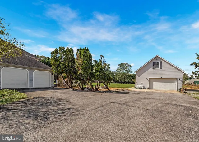 a view of a house with a big yard and large trees