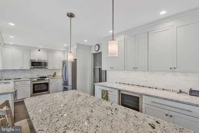 a kitchen with stainless steel appliances kitchen island granite countertop a stove sink and refrigerator