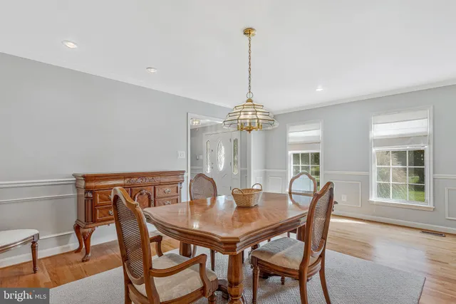 a view of a dining room with furniture a chandelier and wooden floor