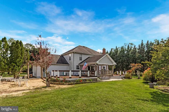 a view of a house with a big yard and large trees