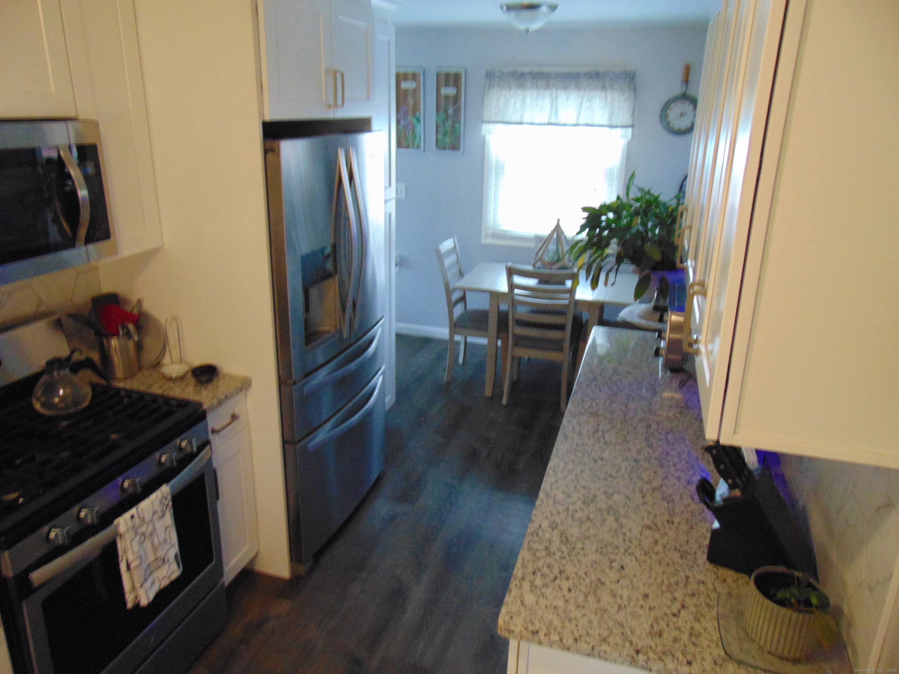57 Alling Street Extension West Haven, CT 06516 - Photo 10 of 38 a kitchen with wooden floor and stainless steel appliances
