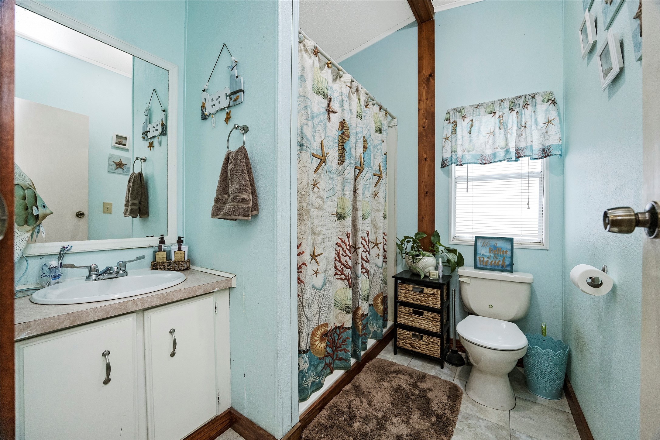 14945 Wiggins Road Conroe, TX 77302 - Photo 13 of 16 a bathroom with a granite countertop toilet a sink and a mirror