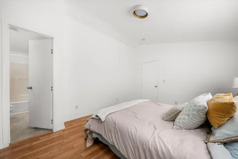 a bedroom with a bed and wooden floor