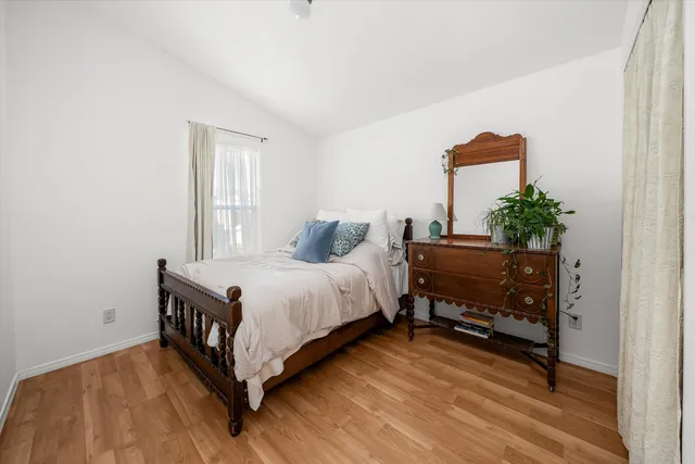 a bedroom with a bed and a potted plant on dresser