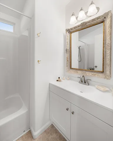 a bathroom with a sink vanity tub and a mirror