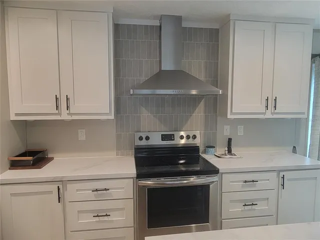 a kitchen with white cabinets and appliances