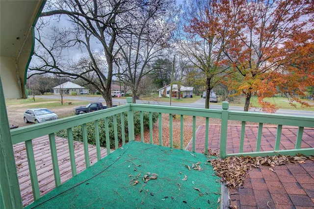 a view of a balcony with wooden floor and fence