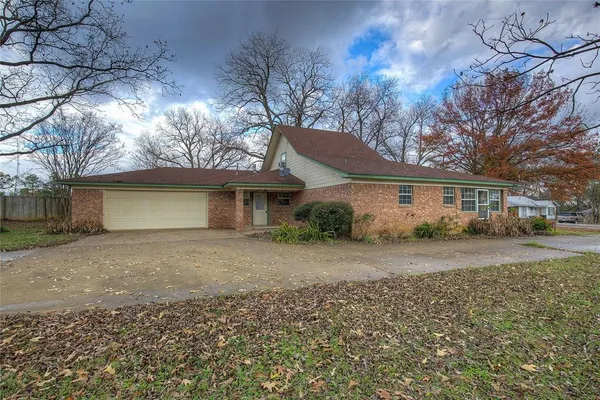 a front view of a house with a yard and trees