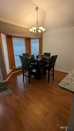 a view of a dining room with furniture and chandelier