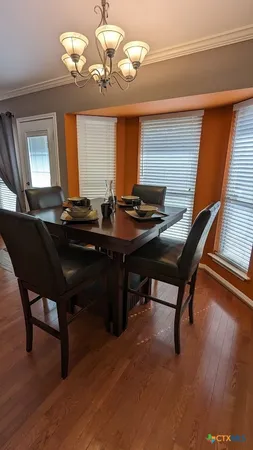 a view of a dining room with furniture wooden floor and chandelier