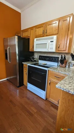 a kitchen with stainless steel appliances granite countertop a stove a sink and a refrigerator