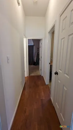 a view of a hallway with wooden floor and closet