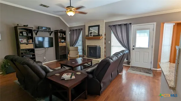 a living room with furniture a fireplace and a window