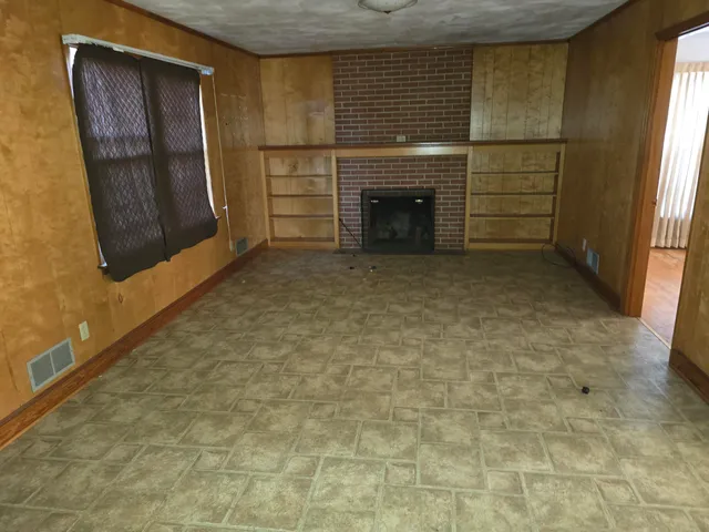 a view of empty room with a fireplace