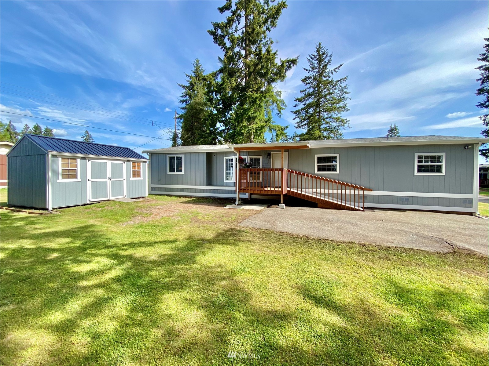 a front view of house with yard and trees in the background