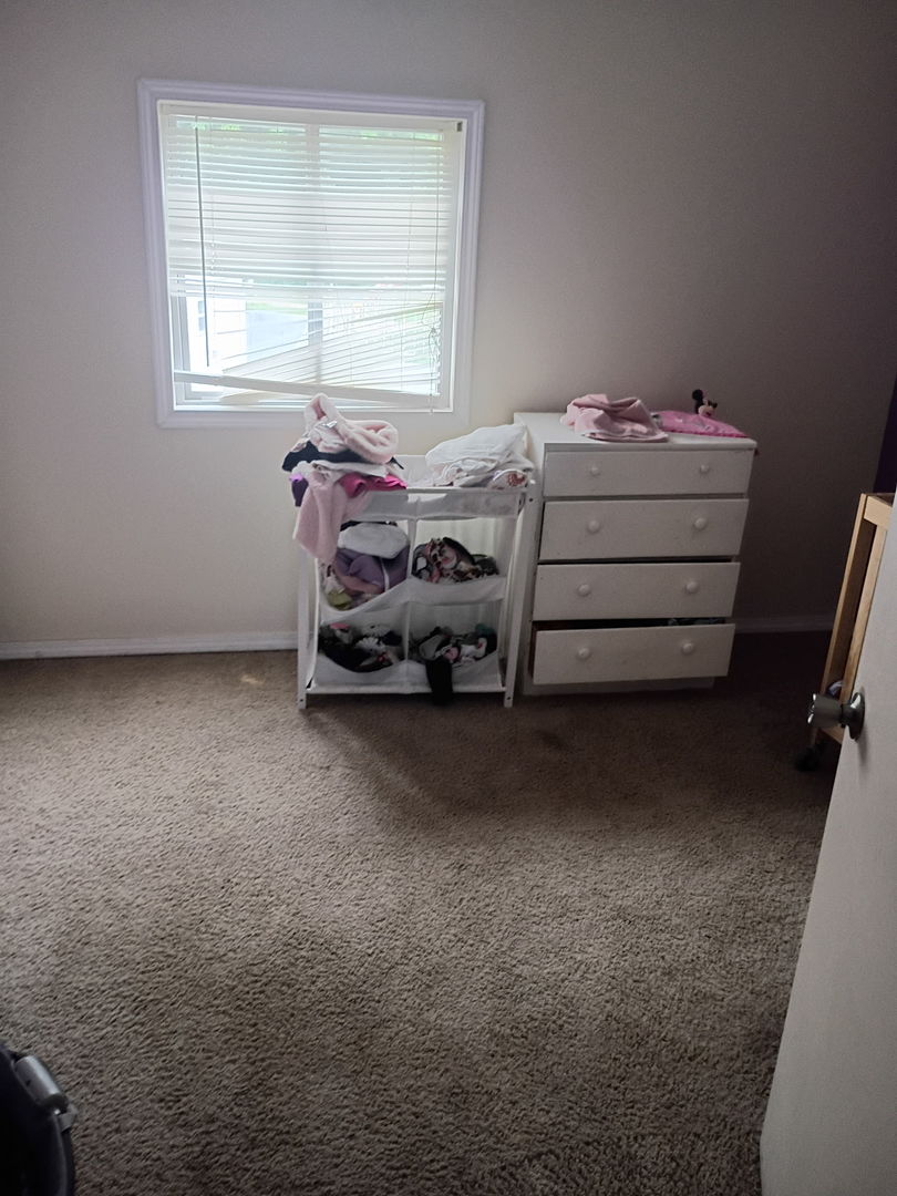1219 South 7th Street Clinton, IA 52732 - Photo 8 of 15 a bed room with a bed and a window