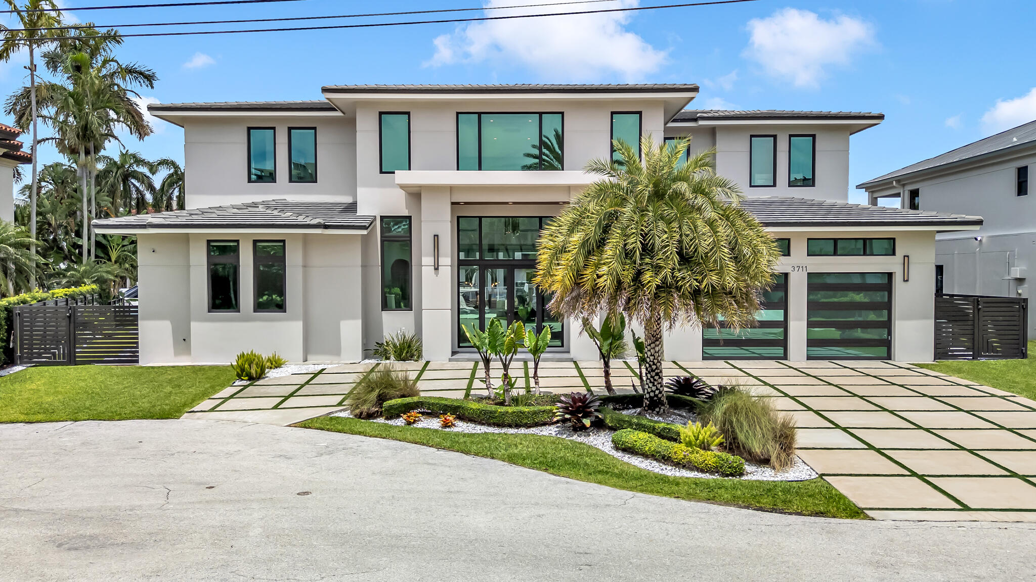 3711 Northeast 30th Avenue Lighthouse Point, FL 33064 - Photo 6 of 57 a front view of a house with a garden